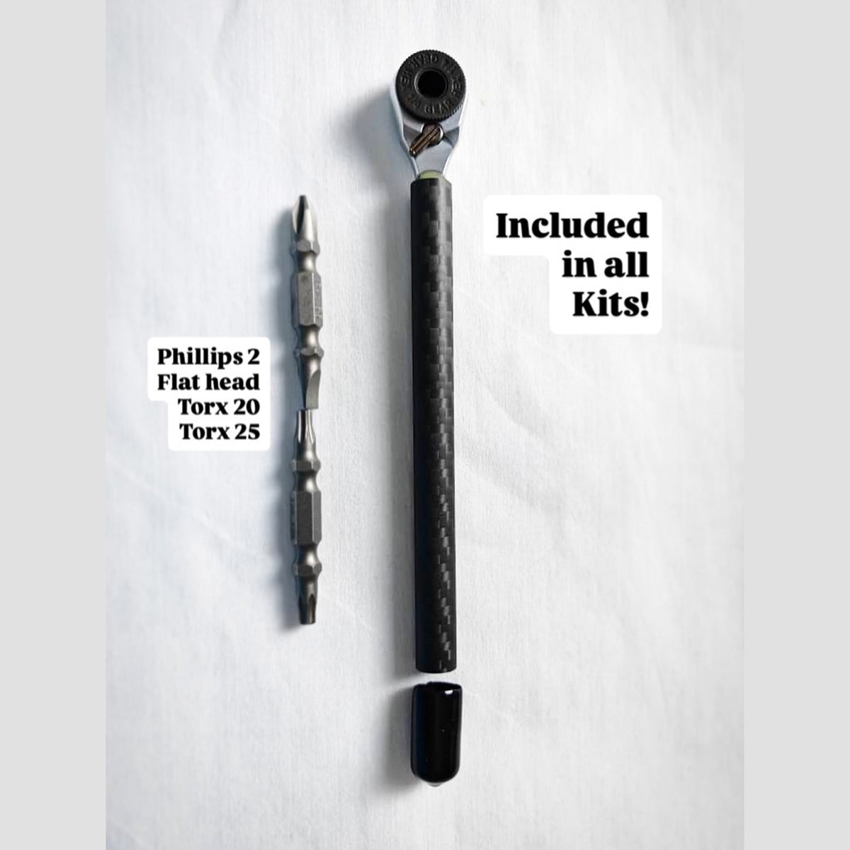 Carbon fiber handle mini ratchet beside its double-ended bits: Phillips 2, flat head, Torx 20 and Torx 25
